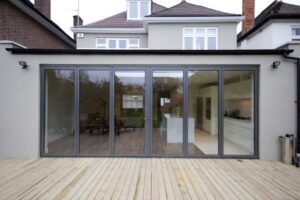 Patio doors to a suburban home with a wooden deck