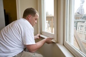 Man installing a window with white frames